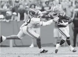  ?? JAMES GILBERT Getty Images ?? Florida’s Dameon Pierce fights off Alabama defender Henry To’oTo’o to gain extra yardage during the first quarter of Saturday’s SEC opener for both teams in Gainesvill­e.