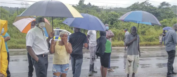  ??  ?? Residents gather at the scene in Williamsfi­eld where bartender Wendy Harrison was gunned down yesterday in what the police believe was a contract killing.