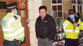  ?? AFP PIC ?? Myanmar’s ambassador to the United Kingdom Kyaw Zwar Minn (centre) standing with police officers locked outside the Myanmar embassy in London on Wednesday.