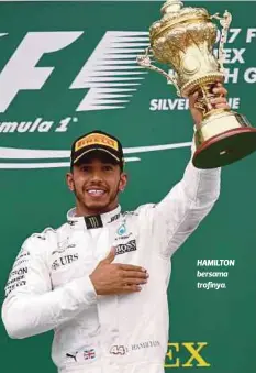  ??  ?? HAMILTON bersama trofinya.