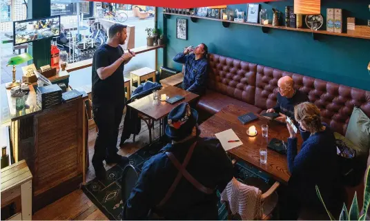  ??  ?? Cheers: Customers enjoy a drink at a pub in Christchur­ch, New Zealand, staying a socially distanced one metre apart