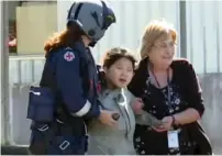  ?? — AP ?? South Korean backpacker Joohee Han, 25, is assisted to a hospital after being rescued in Tully, Queensland, Australia.