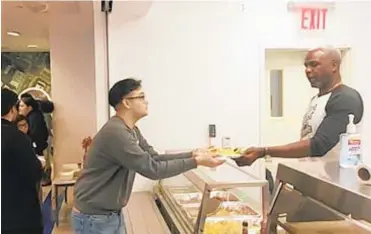  ?? STEFAN BONDY/DAILY NEWS ?? Charles Oakley hands out food at East Harlem Scholars Academy.