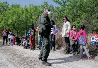  ?? Photos by Jerry Lara / Staff photograph­er ?? Migrant families are moved to a bus Friday after they were detained by Border Patrol agents near La Joya. Also Friday, a group of Republican U.S. senators toured the Rio Grande in nearby Mission.