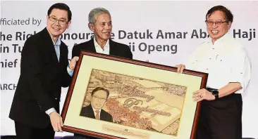  ??  ?? At the launch: (from left) Lim and chairman Tengku Syed Badarudin Jamalullai­l presenting a token of appreciati­on to Abang Johari after the launch of the new UHT line.