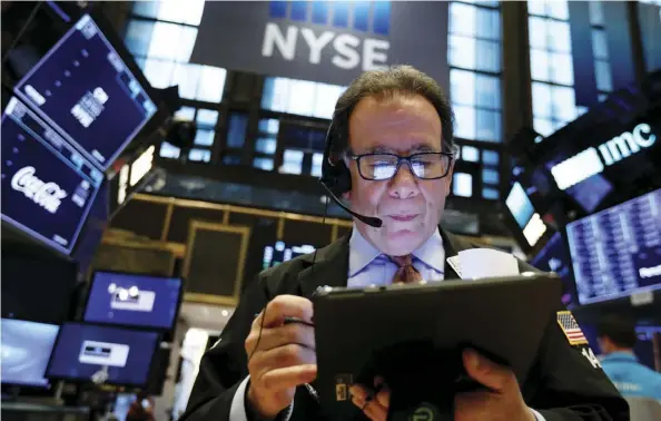  ?? AP Photo/RichARd dRew ?? Trader Sal Suarino works on the floor of the New York Stock Exchange on Friday. The investment industry has its share of misconcept­ions, which writer Tom Bradley tries to clarify.