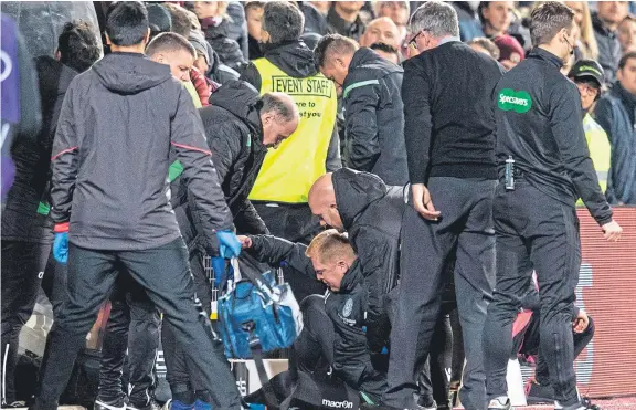  ?? Picture: SNS Group. ?? Hibs boss Neil Lennon is helped to his feet after appearing to be struck by an object from the crowd at Tynecastle.