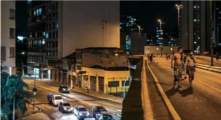  ?? Avener Prado/Folhapress ?? Pedestres caminham no Minhocão, no centro de SP, durante a noite, quando o local vira um parque fechado para carros BICICLETAS