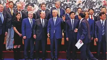  ?? Reuters ?? Wilbur Ross (centre left) chats with Liu He (centre) during a group photograph session after their meeting at the Diaoyutai State Guesthouse in Beijing yesterday.