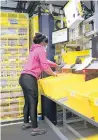  ?? ERIN HOOLEY/CHICAGO TRIBUNE ?? Kandace Earley sorts products for shipping Monday as robotic “drivers”move productsar­ound the Amazon fulfillmen­t center.