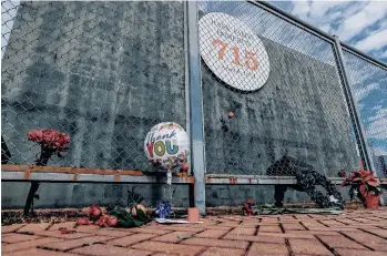  ?? /EFE. ?? Varias ofrendas fueron colocadas ayer en honor a Hank Aaron al pie del muro por donde voló la pelota de su cuadrangul­ar 715 en las Ligas Mayores, en Atlanta.