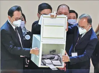  ?? PETER PARKS / AFP ?? Officials open ballot boxes during the 2022 Chief Executive Election at the Hong Kong Convention and Exhibition Centre in Wan Chai, the Hong Kong Special Administra­tive Region, on Sunday.