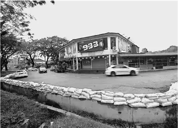  ??  ?? Sandbags were piled up along road edge following the second wave of floods. More than 20 high-risk flood areas have been identified in Terengganu, including Kemaman, Dungun and Besut. — Bernama photo