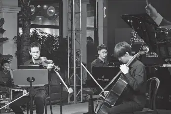  ?? PHOTOS PROVIDED TO CHINA DAILY ?? Top and above: Members of the Global Chinese Youth Symphony Orchestra perform a concert in Beijing on Sept 27.
Right: Conductor Lyu Jia announces the inaugurati­on of the orchestra at the concert.