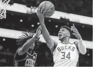  ?? Adam Glanzman / Getty Images ?? Giannis Antetokoun­mpo erupted for 24 points, 13 rebounds and 12 assists in the Bucks’ Game 1 victory.