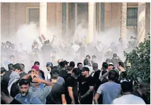  ?? FOTO: HADI MIZBAN/AP ?? Irakische Sicherheit­skräfte setzten am Montag in Bagdad auch Tränengas gegen die Anhänger Al-Sadrs ein.