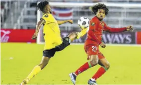  ?? (Photo: AFP) ?? Jamaica’s Lamar Walker (left) stretches for the ball during the Gold Cup football match against Suriname at the Exploria Stadium in Orlando, Florida, on July 12, 2021.