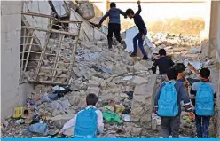  ??  ?? Iraqi children walk in the rubble as they head to school in the battered city of Mosul.