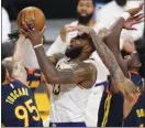  ?? AP photo ?? LeBron James of the Lakers is defended by three Warriors during the first half of Los Angeles’ 117-91 victory over Golden State on Sunday.