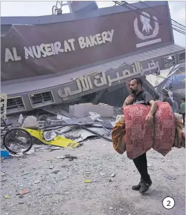  ?? ?? 2. A Palestinia­n walks past the Al Nuseirat Bakery, destroyed in an Israeli airstrike, in Nusseirat refugee camp Gaza Strip.