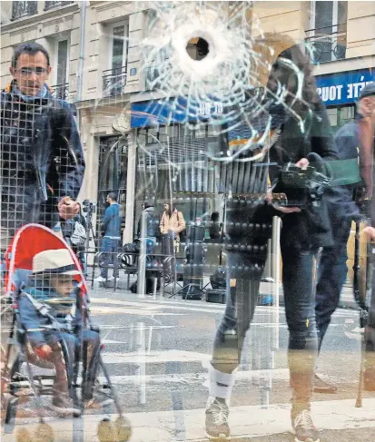  ??  ?? Dort, wo der Angreifer getötet wurde, blieb ein Einschussl­och im Fenster eines Cafés.