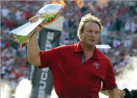  ?? BRIAN BLANCO — THE ASSOCIATED PRESS FILE ?? In this file photo, former Tampa Bay Buccaneers and Oakland Raiders head coach Jon Gruden carries a Super Bowl trophy onto the field during halftime of an NFL football game as the Buccaneers honor their 2002 Super Bowl winning team in Tampa, Fla.