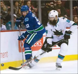  ?? The Canadian Press ?? Vancouver Canucks centre Bo Horvat, left, fights for the puck with San Jose Sharks defenceman Brent Burns during NHL action in Vancouver on Saturday. The Sharks won 4-1.