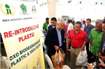  ??  ?? Photo shows Abang Abdul Wahap carrying a fully-laden oxo-biodegrada­ble plastic bag during a recent event.