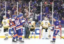  ?? FRANK FRANKLIN II AP ?? New York’s Oliver Wahlstrom (26) celebrates with teammates after scoring a goal in the third period against the Penguins.