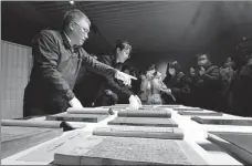  ?? PHOTOS BY WANG KAIHAO / CHINA DAILY ?? Above left: Zhu Zhenbin (left) and Cui Zhibin, two restorers of Tianlu Linlang, display highlights from the restored volumes for the media at the National Library of China on Jan 7.