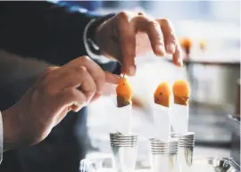  ?? Stephen Lam / Special to The Chronicle 2017 ?? At the French Laundry, a chive is placed onto a salmon cornet. Thomas Keller includes many of the restaurant’s recipes in his new cookbook.