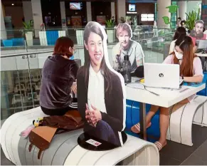  ?? — arT CHEN/The Star ?? Star-studded study group: Sunway university students studying at the communal areas on their campus accompanie­d by cardboard cutouts of celebritie­s like Nicol david and Ed Sheeran.
