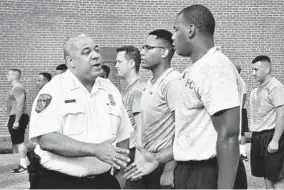  ?? AMY DAVIS/BALTIMORE SUN ?? Baltimore City Police Commission­er Michael Harrison greets the 29 new trainees after their morning exercise regimen over the summer.