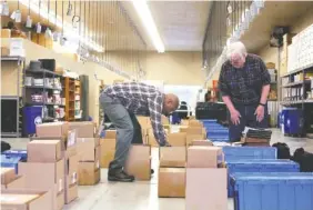  ?? STAFF PHOTO BY ERIN O. SMITH ?? Ty Jacobs, a voting machine technician, and Rodney Strong, a part-time worker, grab boxes Monday at the Hamilton County Election Commission to send to voting precincts, Boxes with ballots, pens, voting official informatio­n, voting machines, privacy dividers, water and other supplies were loaded into the backs of cars to be taken to voting locations throughout Hamilton County.