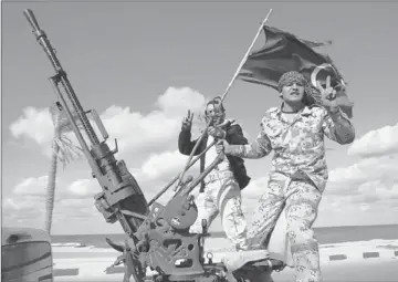  ?? Abdel Magid Al Fergany ?? MILITIA MEMBERS parade through Tripoli, the Libyan capital, last month. The ruling Transition­al National Council lacks the muscle to rein in the armed groups, which have become a law unto themselves.