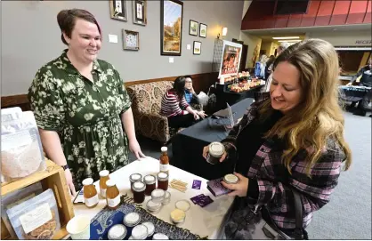  ?? CLIFF GRASSMICK — STAFF PHOTOGRAPH­ER ?? Andi Olson, right, buys honey from Amanda Rose of Artemisia and Rose Herbals at the annual Windows to Wellness Fair Saturday. The city of Longmont hosted the fair at the Longmont Senior Center, 910Longs Peak Ave., to promote healthy living.