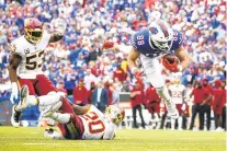  ?? JEFFREY T. BARNES/AP ?? The Buffalo Bills’ Dawson Knox dives past the Washington Football Team’s Bobby McCain, on ground, and Jon Bostic during the second half Sunday in Orchard Park, New York.