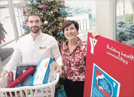  ?? BOB TYMCZYSZYN THE ST. CATHARINES STANDARD ?? YMCA’s Nathan Smith and FACS Niagara’s Ann Godfrey at the Walker family YMCA with donations for the Cool Yule Program for youth transition­ing from foster care.