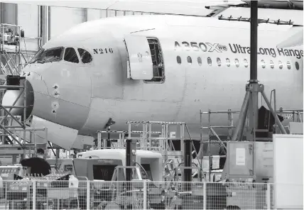  ??  ?? An Airbus A350 X UltraLong Range is pictured on the final assembly line at Airbus headquarte­rs in Blagnac, near Toulouse in France. The European air giant said yesterday its half-year profits plunged, as the company is hit by delays in the delivery of...