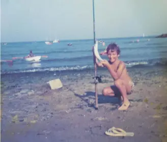  ??  ?? Above Mitch Tonks on the beach at Portmellon, showing off his first catch