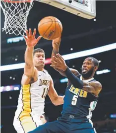  ?? Ringo H.W. Chiu, The Associated Press ?? Nuggets guard Will Barton looks to pass the ball against Los Angeles center Brook Lopez on Sunday night at Staples Center in Los Angeles.