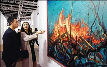  ??  ?? Chinese investment banker Huang Xiaoshuai, 26, and his wife Wei Mengyuan chat in front of their newly acquired painting by Chinese artist Zeng Fangzhi, on Wednesday during an interview at Art Basel in Hong Kong.