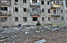  ?? ?? A rescuer works outside a residentia­l building damaged after Russian strikes in Kharkiv.