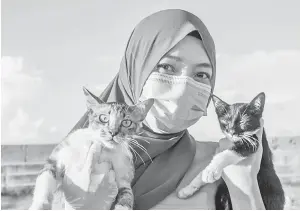  ??  ?? MESRA: Nor Izyan bersama kucing yang diberi nama Jingga (kiri) dan Tammy yang merupak se- bahagian kucing jalanan yang diberi makanan dan rawatan olehnya semalam.