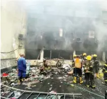  ?? ?? Responders retrieving materials from the burnt warehouse