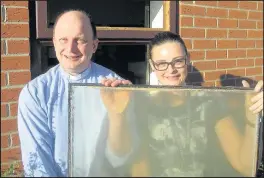  ??  ?? The Rev John Whittaker, vicar of St Mary’s with St Francis, Hinckley, and Joanne Boffey, manager of St Francis Community Centre on Tudor Road, Hinckley, welcome the replacemen­t of outdated window glass at the centre with the help of financial support...