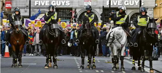  ?? Dylan Martinez/Reuters ?? Policiais acompanham ato antirracis­mo e contra o ativista de extrema direita Tommy Robinson realizado neste domingo (10), em Londres