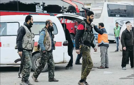  ?? OMAR HAJ KADOUR / AFP ?? Guerriller­os islamistas evacuados de Guta Oriental, ayer a su llegada a la población de Qalaat al Madiq