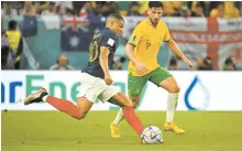  ?? Korea Times photo by Choi Won-suk ?? France’s Kylian Mbappe dribbles past Australia’s Mathew Leckie during the 2022 Qatar World Cup group stage match at Al Janoub Stadium in Al Wakrah, Wednesday.