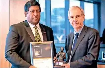 ??  ?? The Banker’s Chief Editor Brian Caplen handing over the award to Minister Ravi Karunanaya­ke